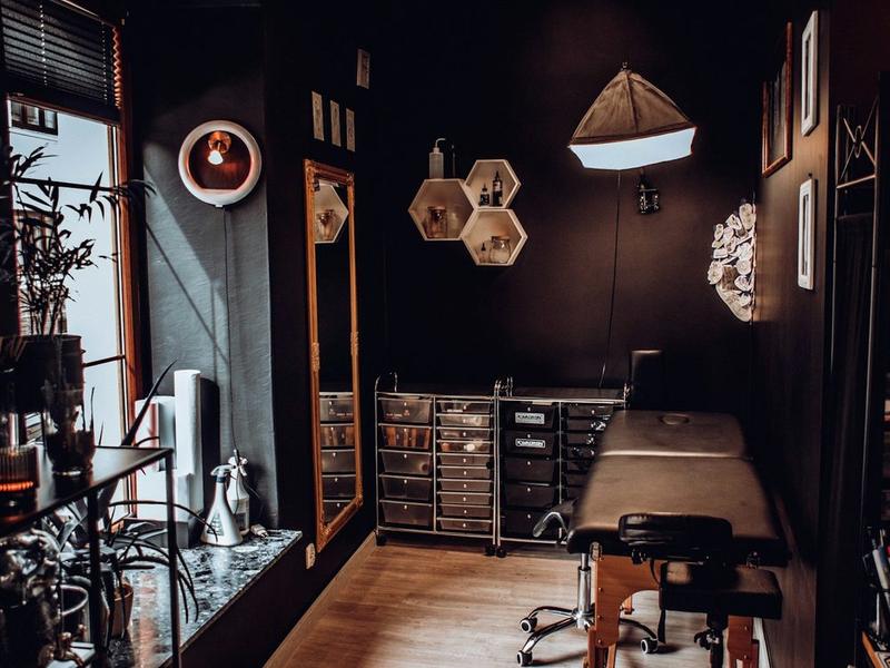 Un poste de tatouage vide : la table, la lampe, personne.